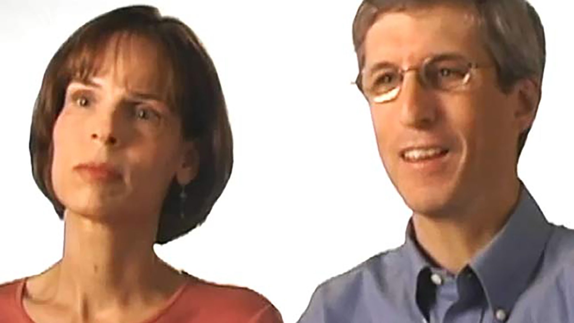 A middle-aged woman and man are interviewed against a white background