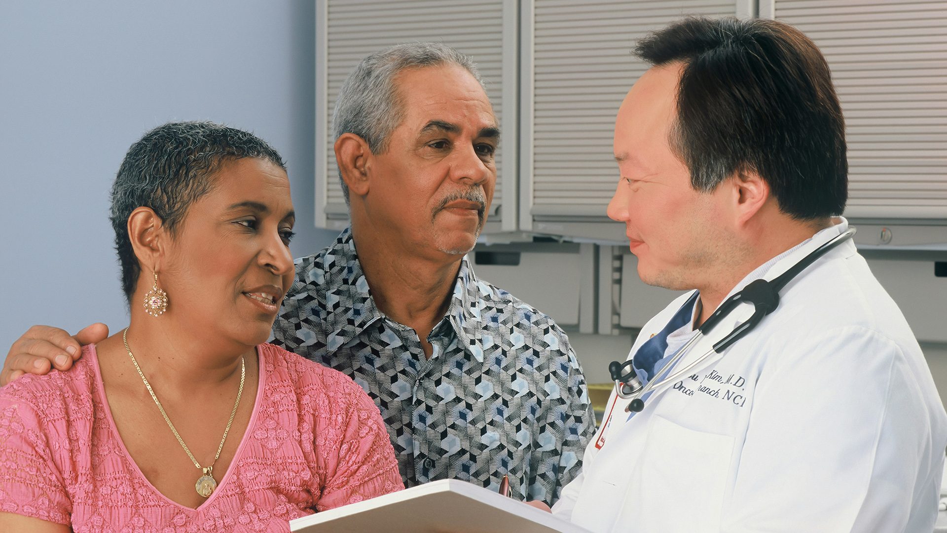 A senior woman and man speaking with a male doctor
