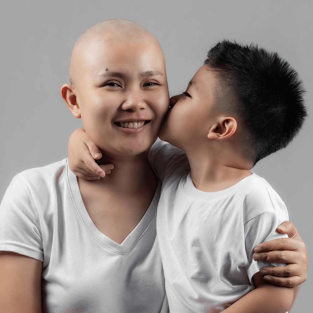 Young boy kisses his mother, a cancer patient