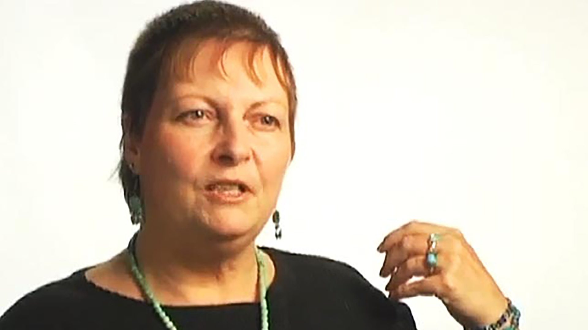 A middle aged woman wearing a black shirt being interviewed