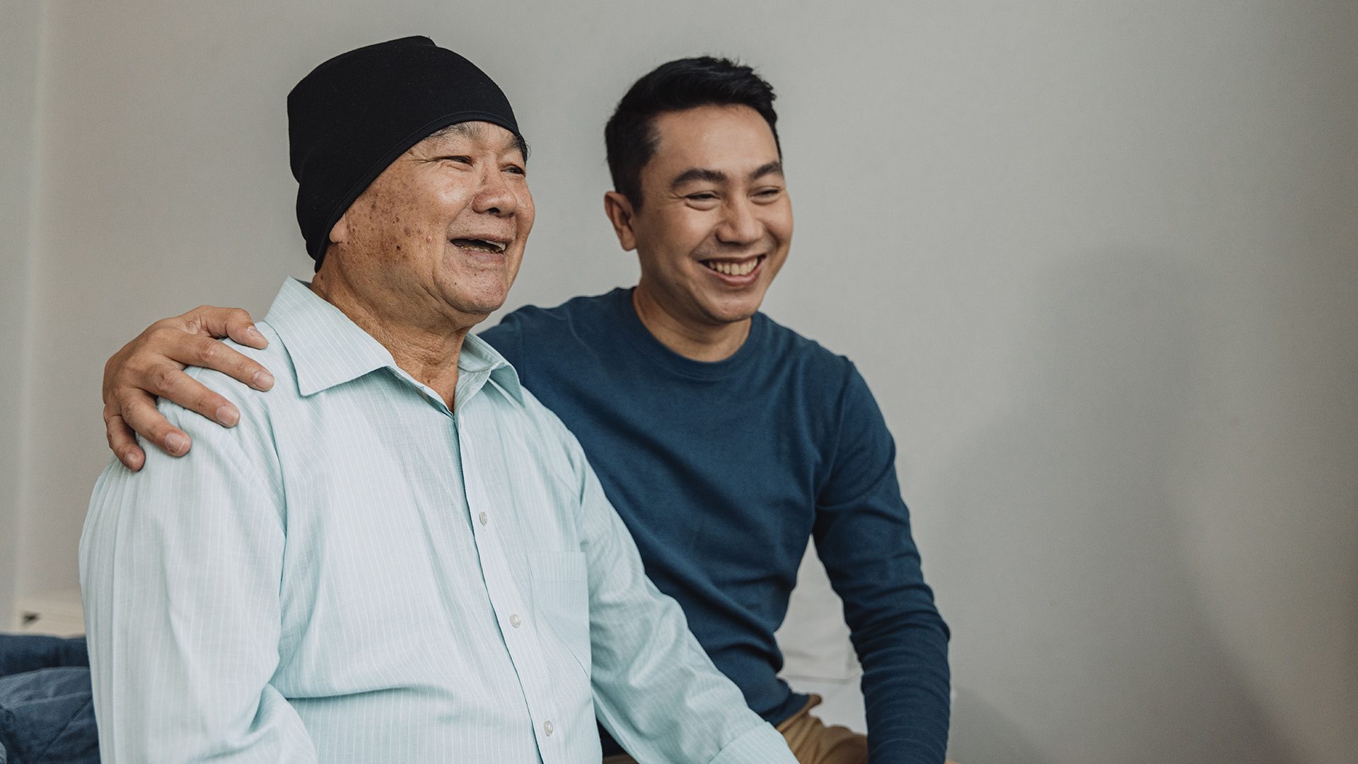 A son with his arm around his father, a cancer patient