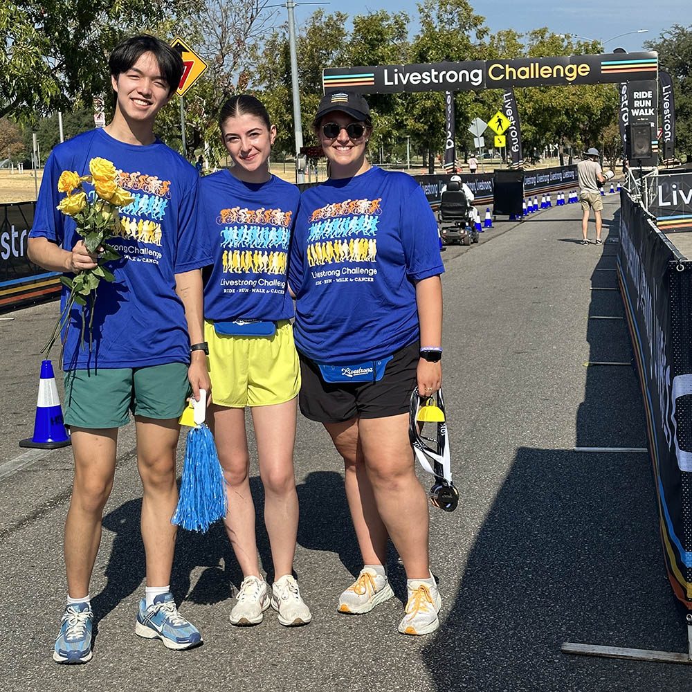 3 young adults wearing blue shirts at race