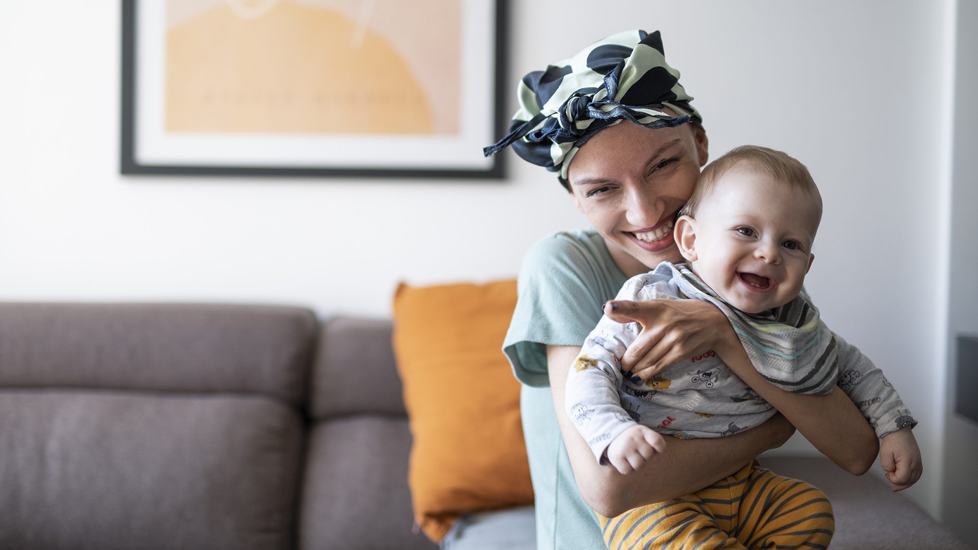 Young female cancer patient holding her baby son.