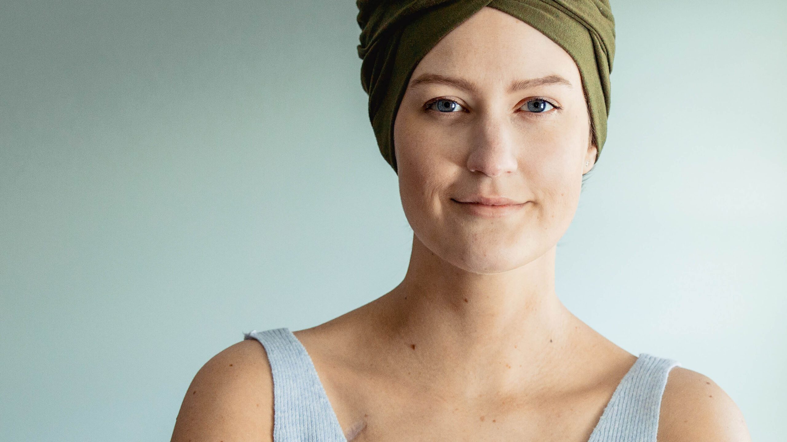 Portrait of a female cancer survivor wearing a green head wrap