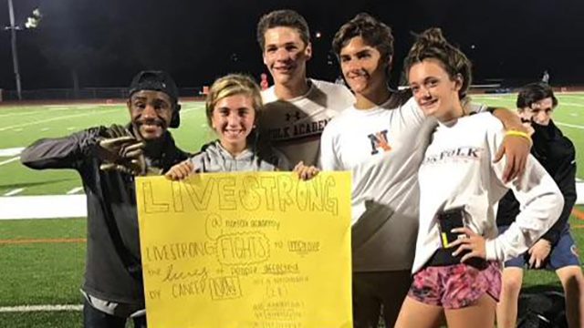 Group of teens holding a yellow sign