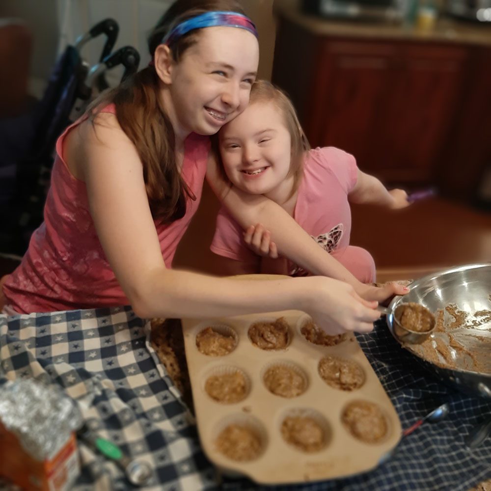 Two happy girls making muffins