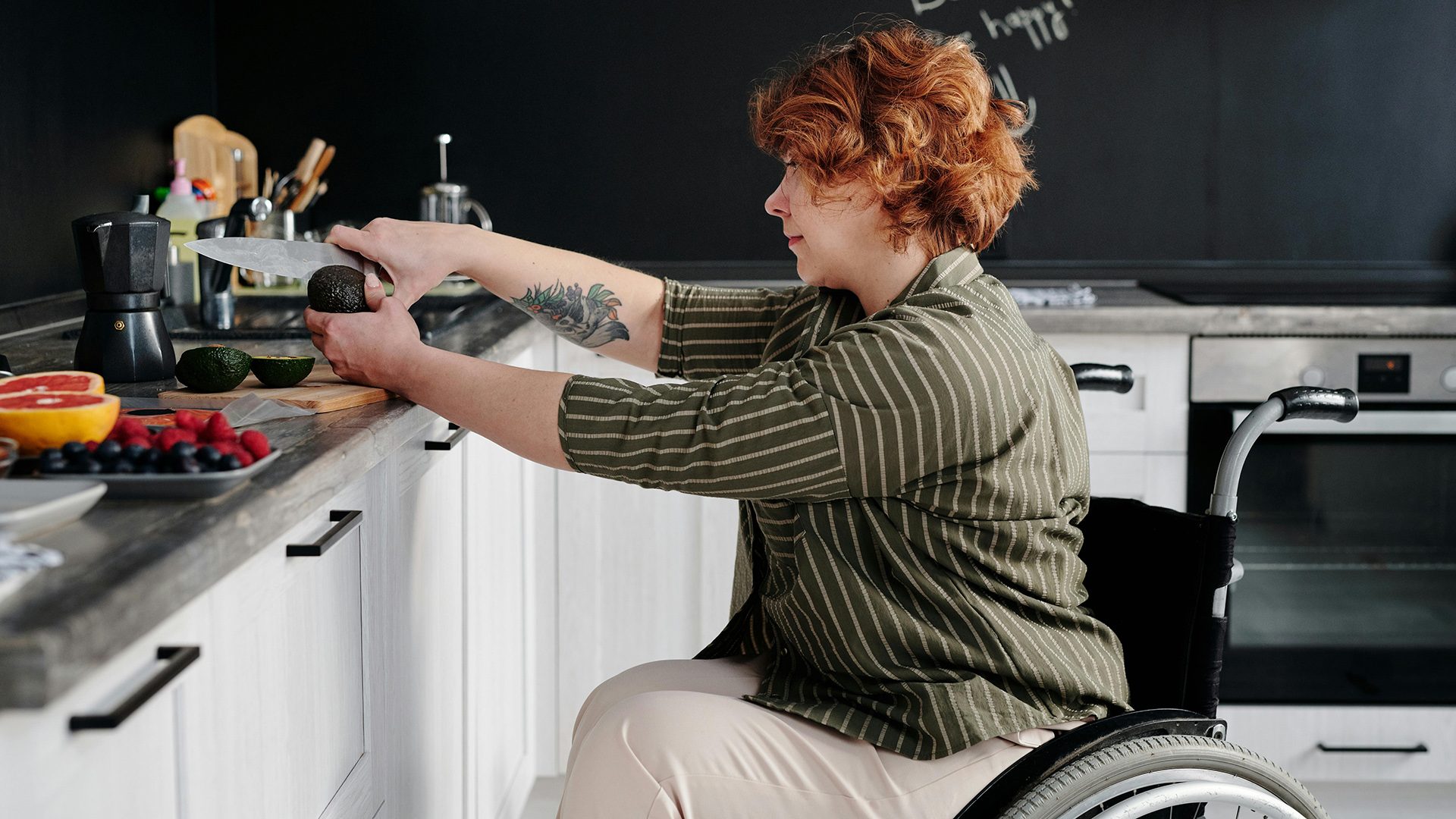 A woman in a wheelchair preparing food