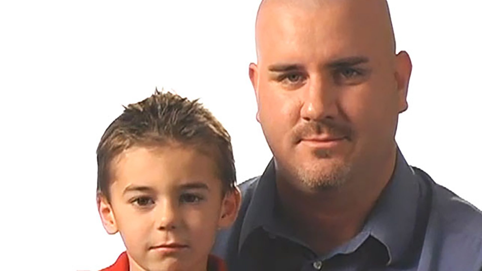 A portrait of a young boy and his father against a white background.