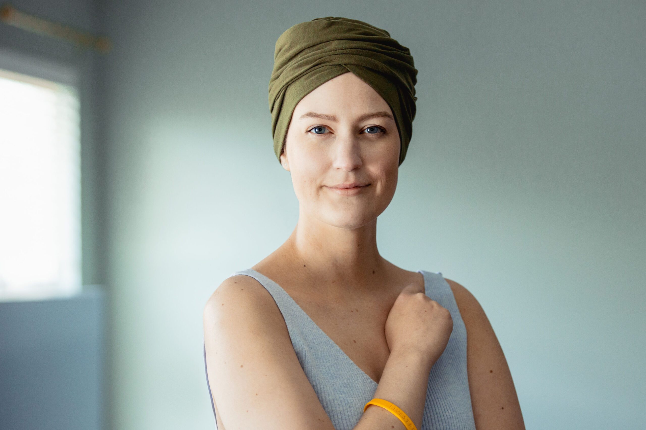Portrait of a woman cancer survivor wearing a head wrap and Livestrong wristband