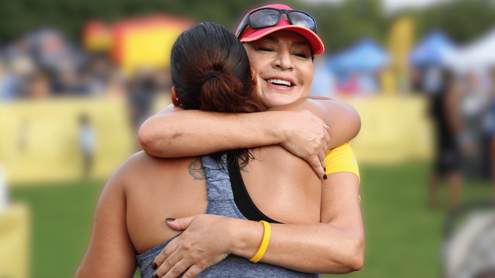 Two women in athletic clothing share a hug
