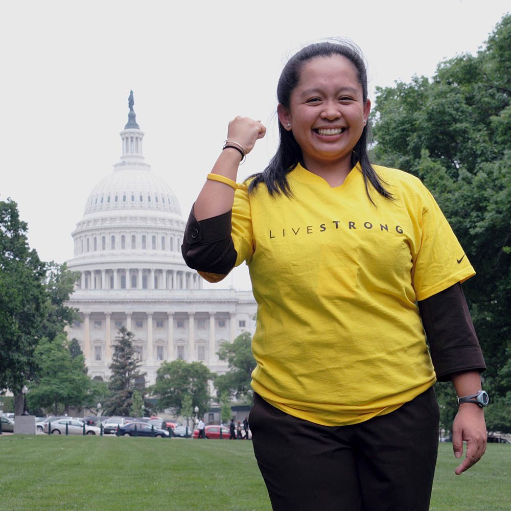 Woman wearing yellow Livestrong merchandise standing in front of U.S. Capitol