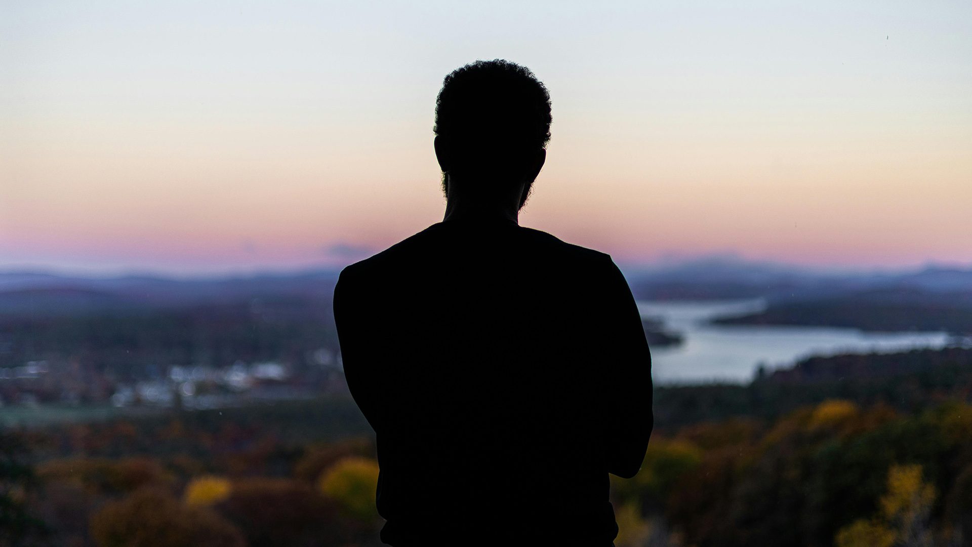 A man looking out at a sunset