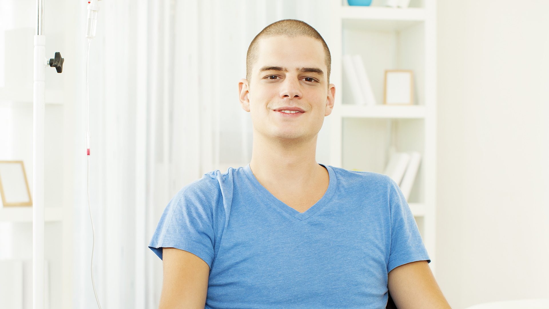 A young adult male cancer survivor at home