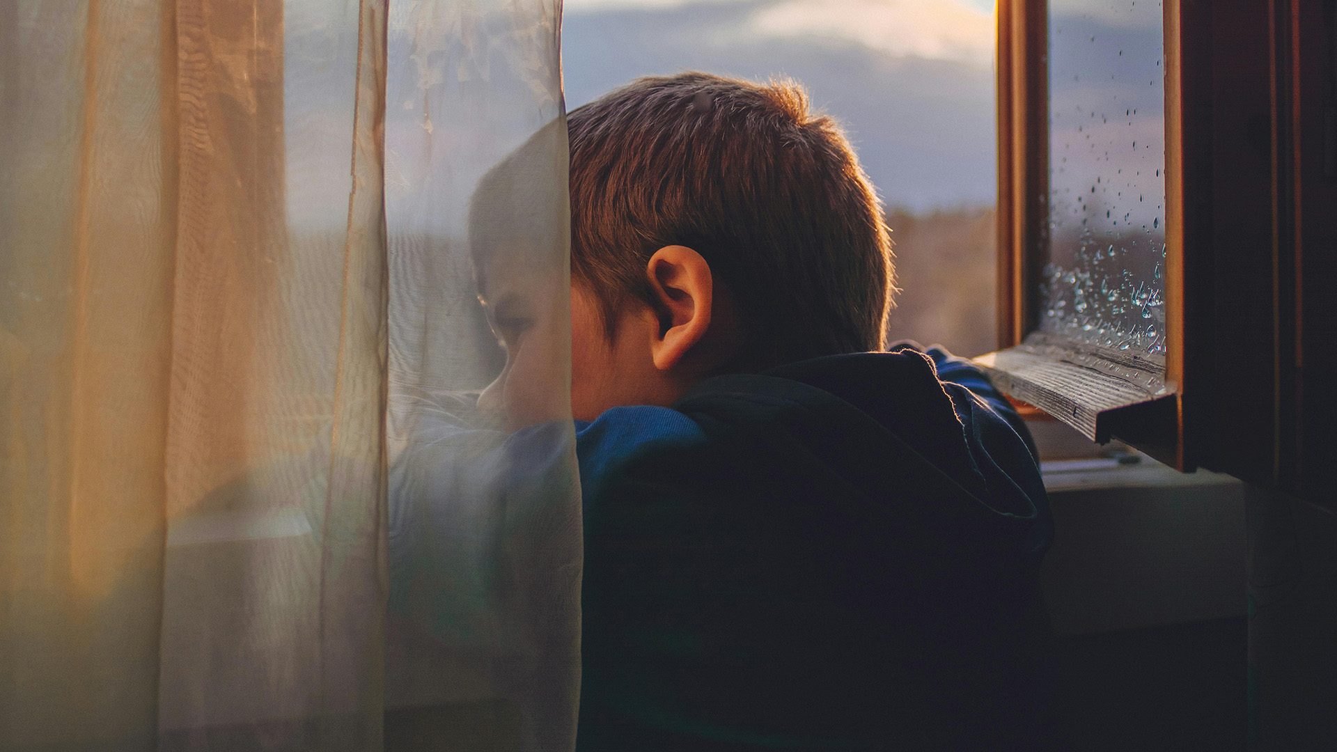 A young boy looking out a window