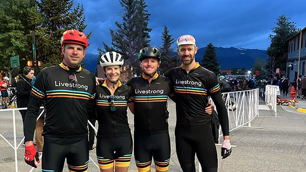 A group of cyclists wearing black uniforms
