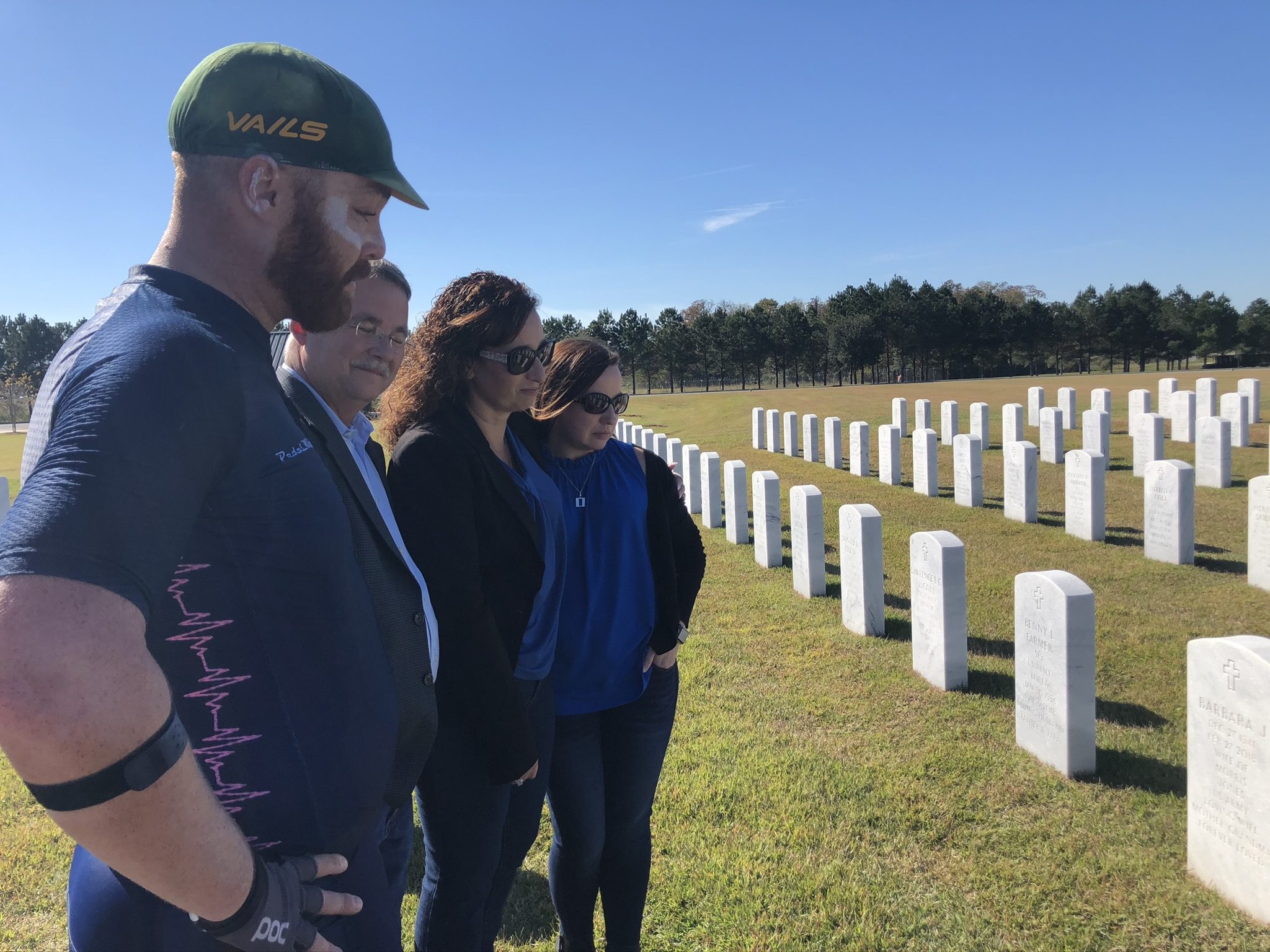 A group of people stand in a cemetery