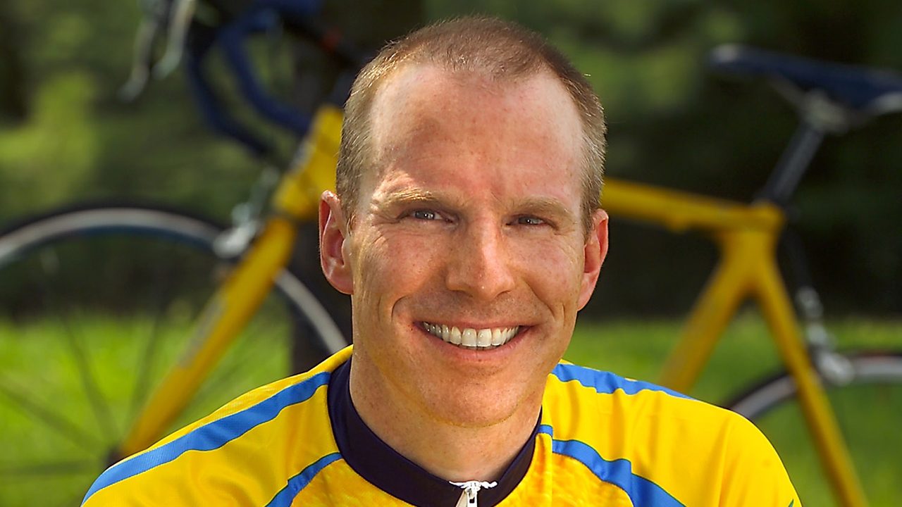 A portrait of a cyclist wearing a yellow jersey