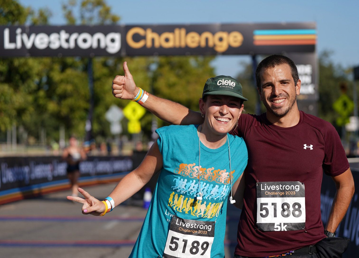 A woman and man smiling at the finish line of a run