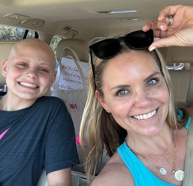 A mother and daughter pose in the car