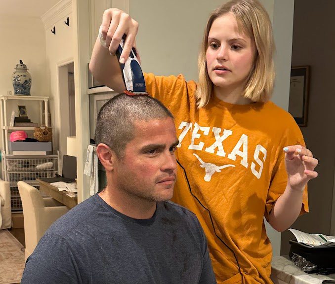 A teen girl shaving her father's head