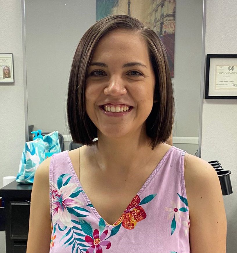 A woman poses in a hair salon after a haircut