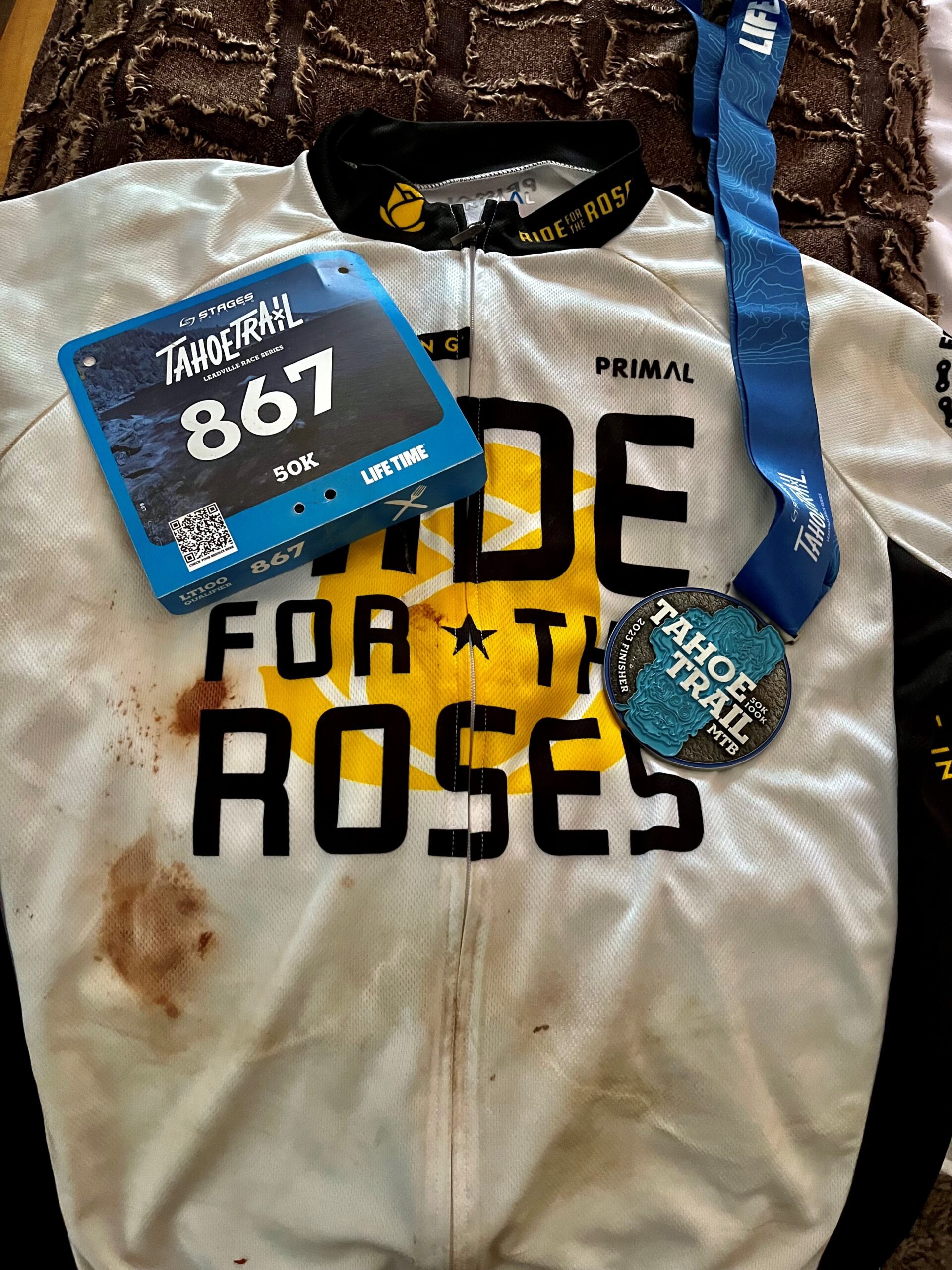 A cycling jersey, bib number, and medal