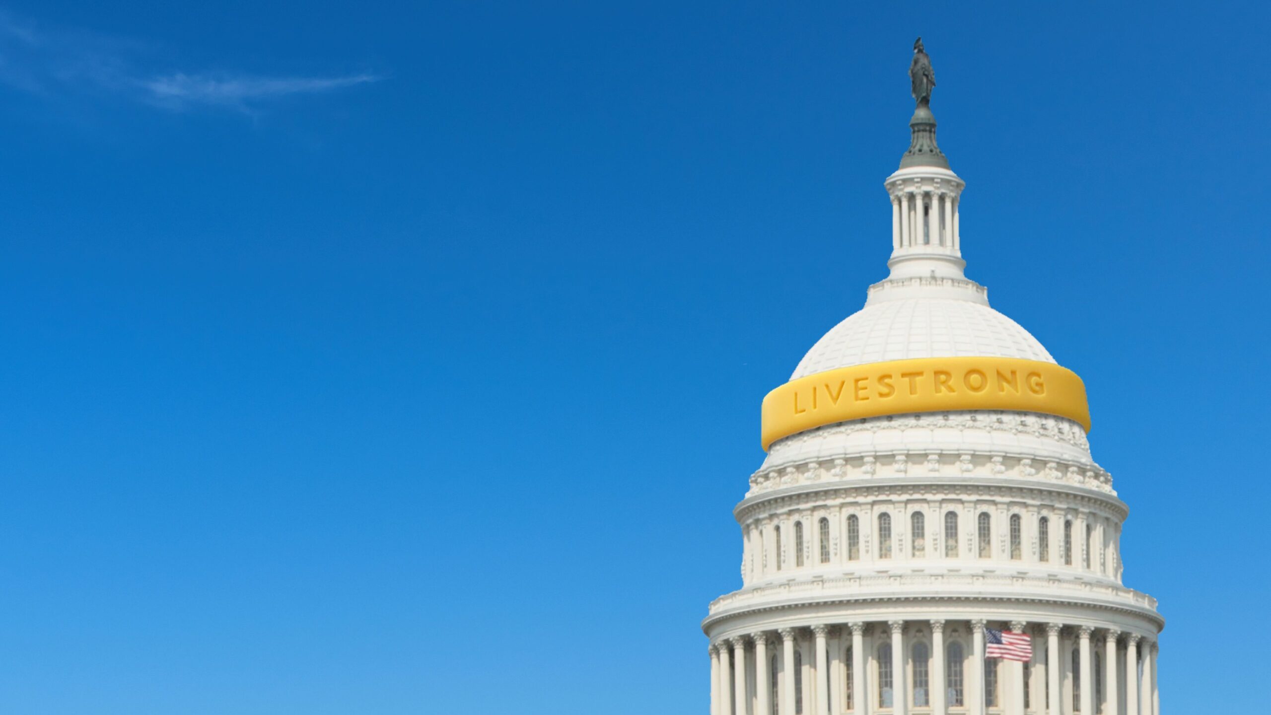 United States Capitol building with a yellow wristband wrapped around it against a blue sky background