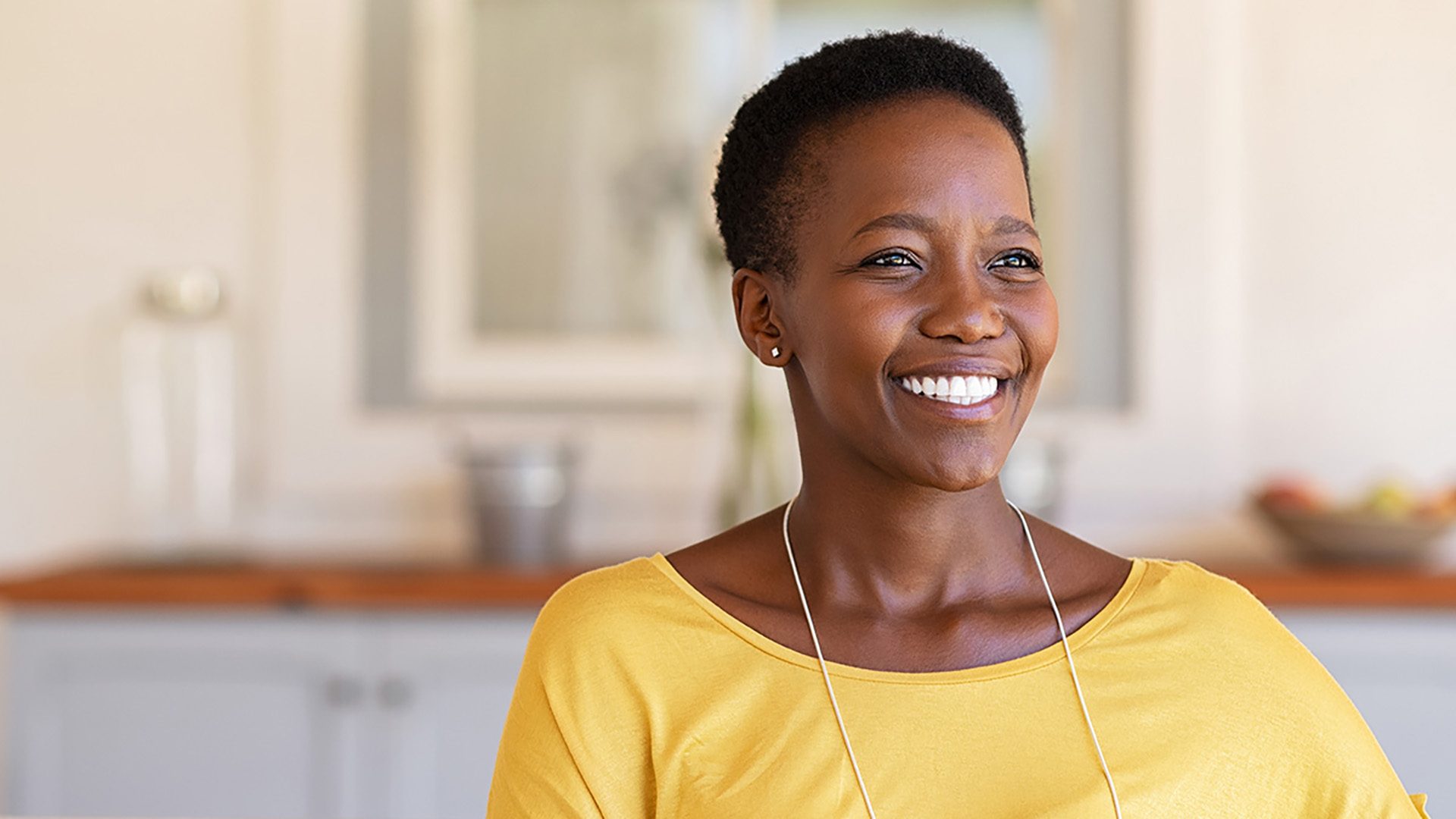 A mature woman smiling and looking into the distance