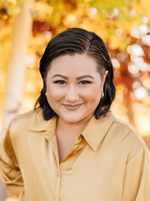 An adult woman with a background of autumn trees
