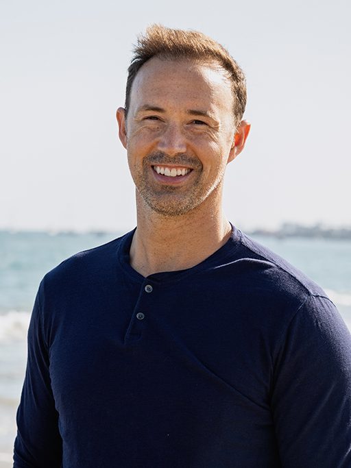 A portrait of a man in front of the ocean