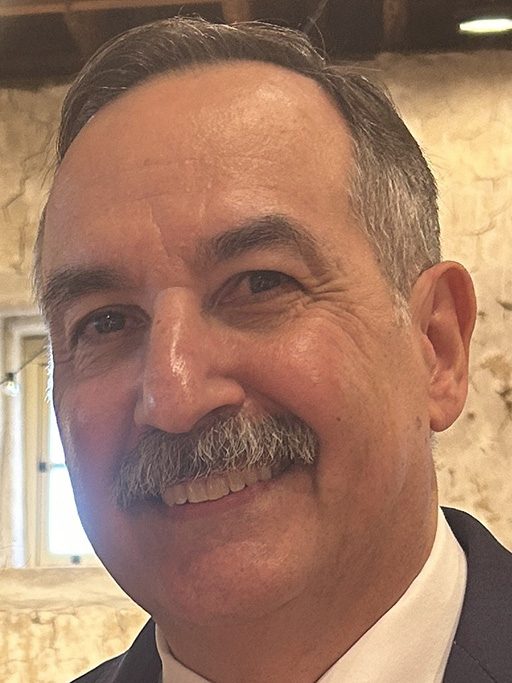 A close-up of an adult man with a mustache