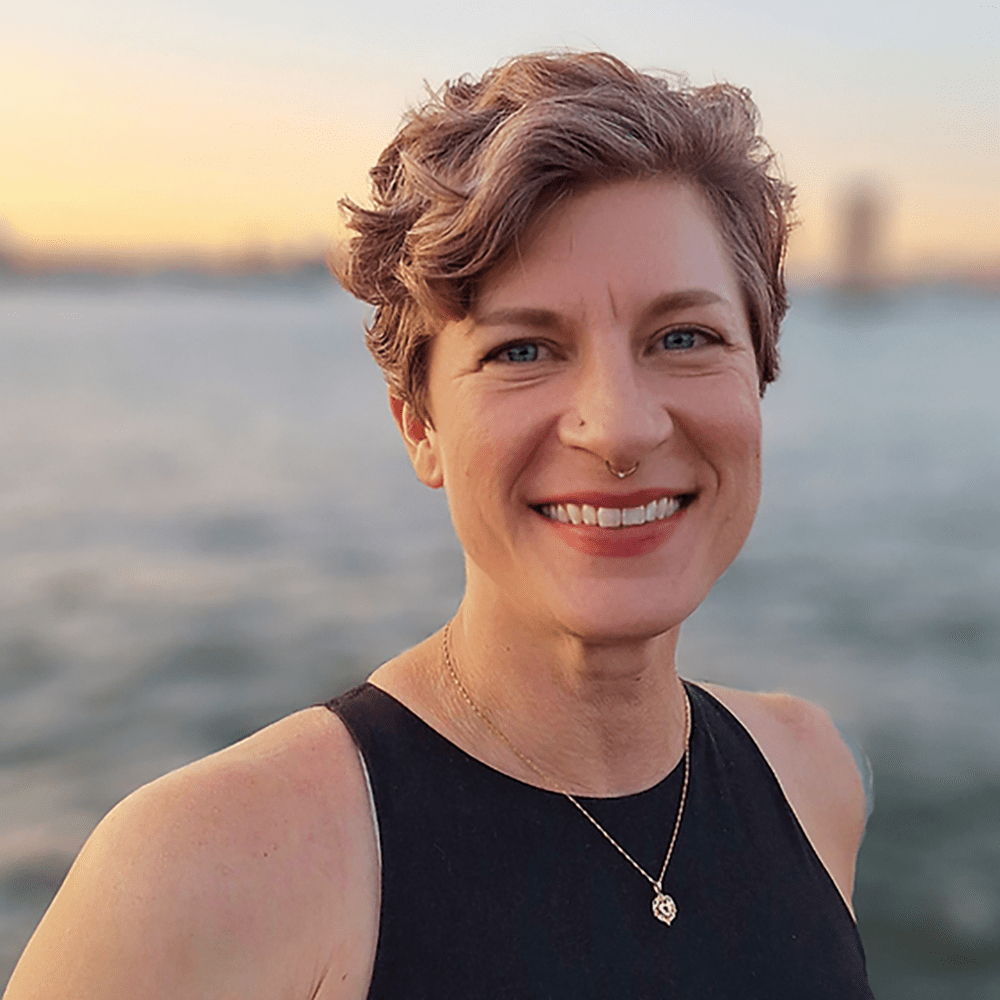 A portrait of an adult woman next to a body of water
