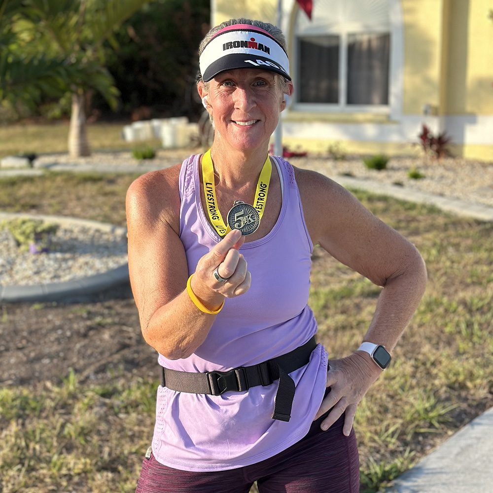 A woman in exercise apparel wearing a medal
