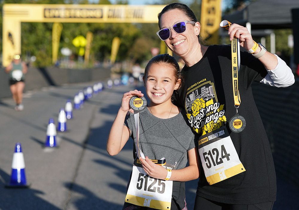 Smiling mother and daughter at the finish line of a run
