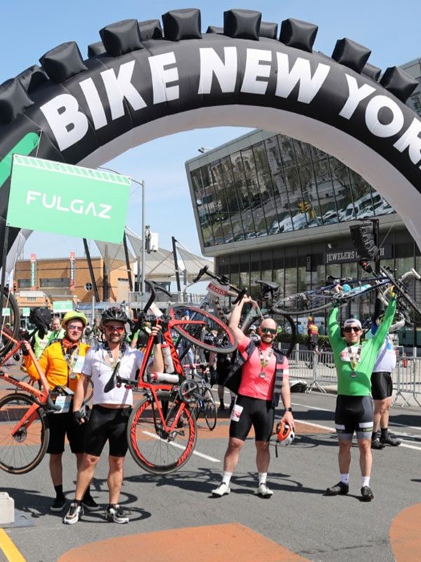 Group of cyclists at the finish line, celebrating finishing the TD Five Boro Bike Tour