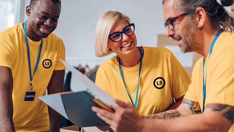 Group of colleagues working together wearing yellow Livestrong branded t-shirts