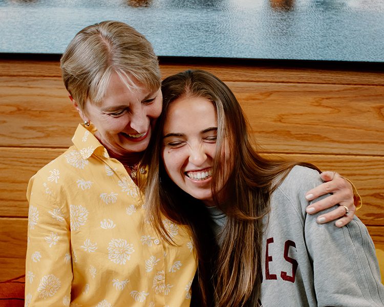 A mother and daughter hugging and smiling