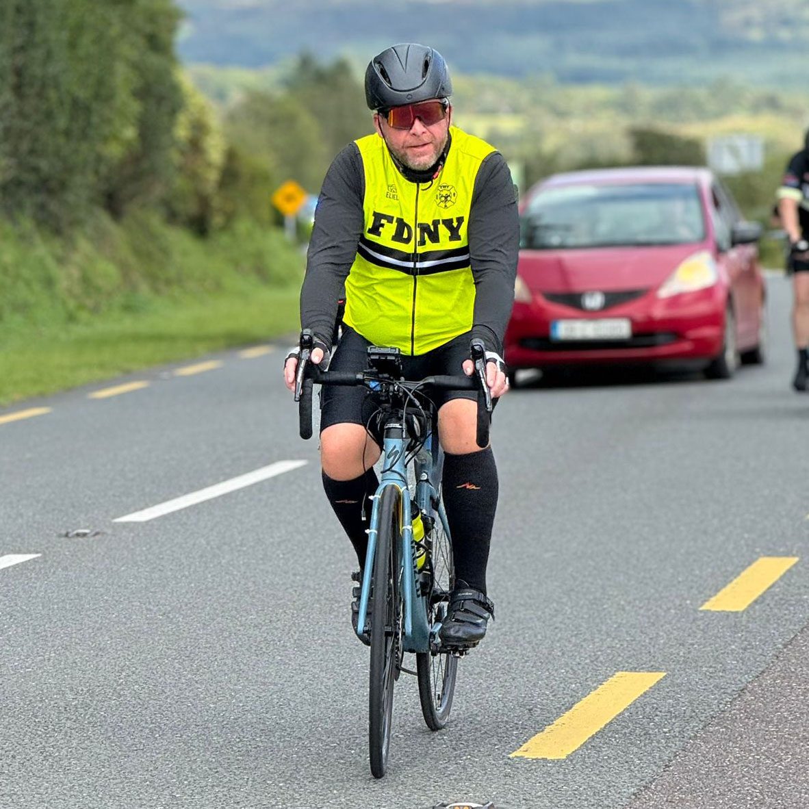 Man cycling in FDNY neon jersey
