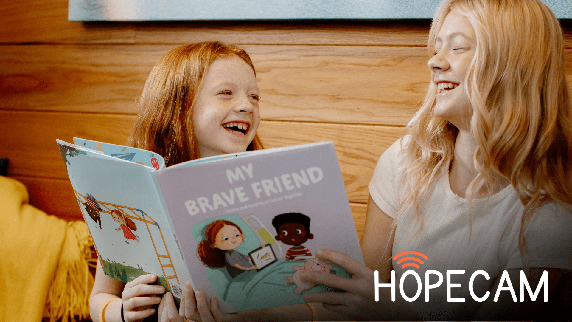 Two girls laughing and reading a book