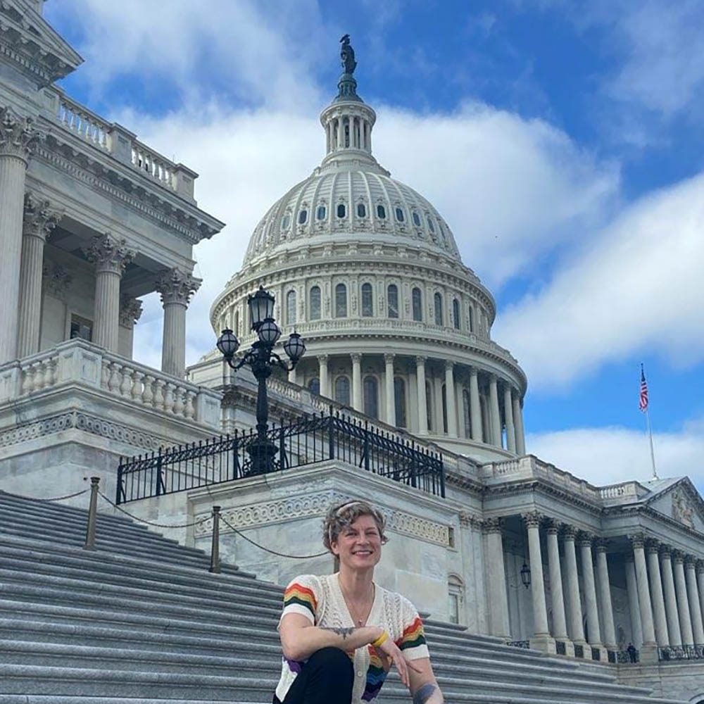 Una mujer sentada en las escaleras del Capitolio de los Estados Unidos.