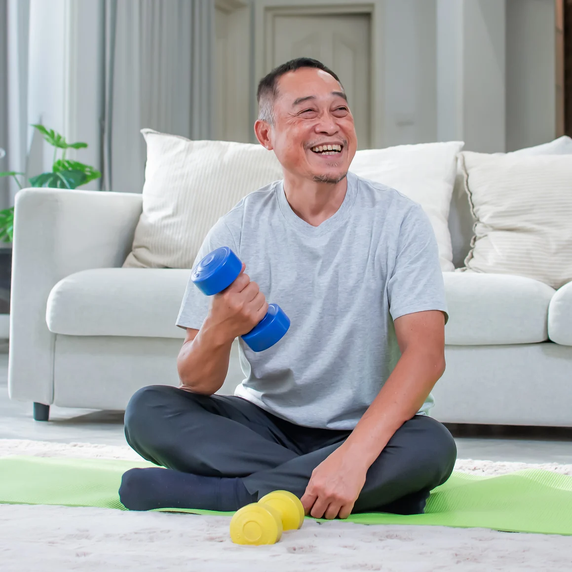 A senior man lifting weights at home