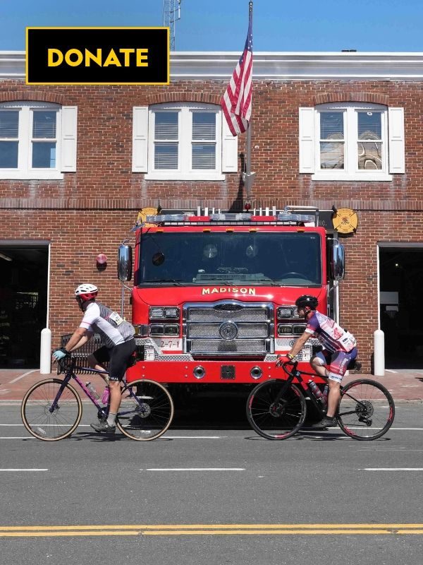 2 people cycling in front of a fire truck